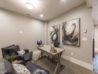 This stunning home office boasts a tranquil atmosphere with plush seating and large abstract art pieces.