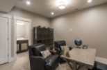 This stunning basement boasts a stylish office space, complete with comfortable leather armchairs and a rustic wooden desk.