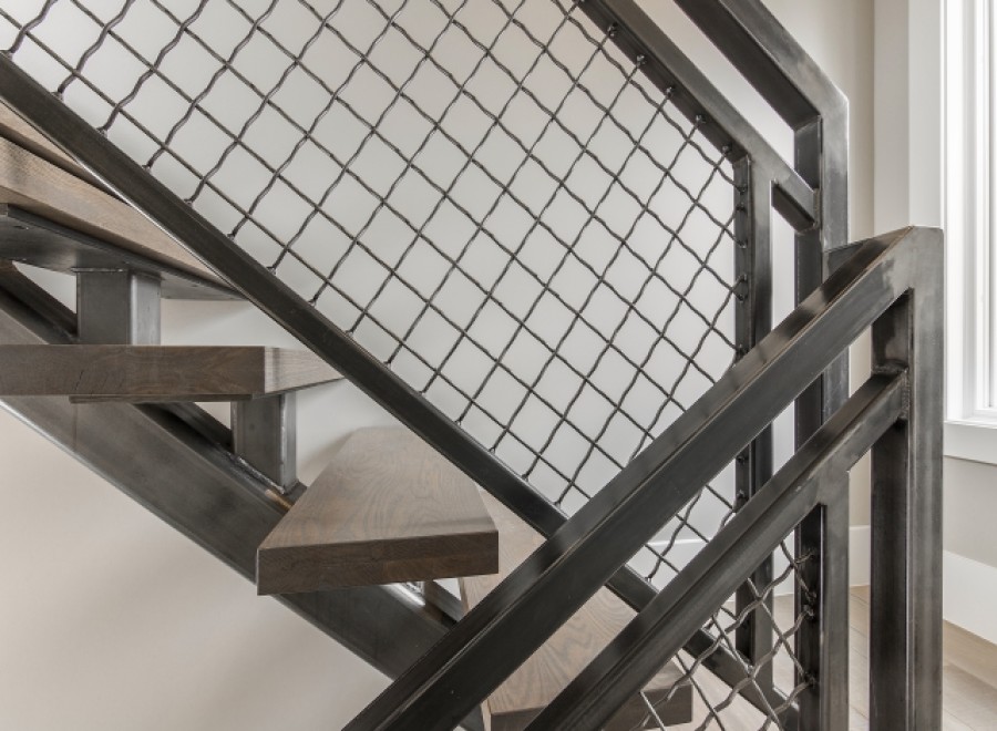 Modern staircase with metal railing and wood steps.