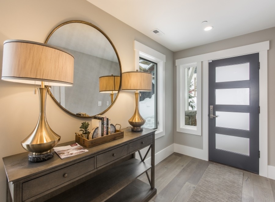 This stunning entryway boasts a sleek, modern design with elegant gold table lamps and a sophisticated console table.