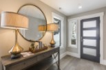This stunning entryway boasts a sleek, modern design with elegant gold table lamps and a sophisticated console table.