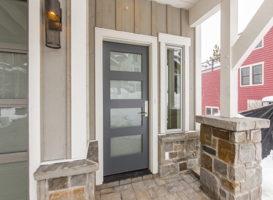 This stunning home boasts a modern gray front door with sleek glass panels, enhancing curb appeal.