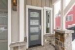 This stunning home boasts a modern gray front door with sleek glass panels, enhancing curb appeal.