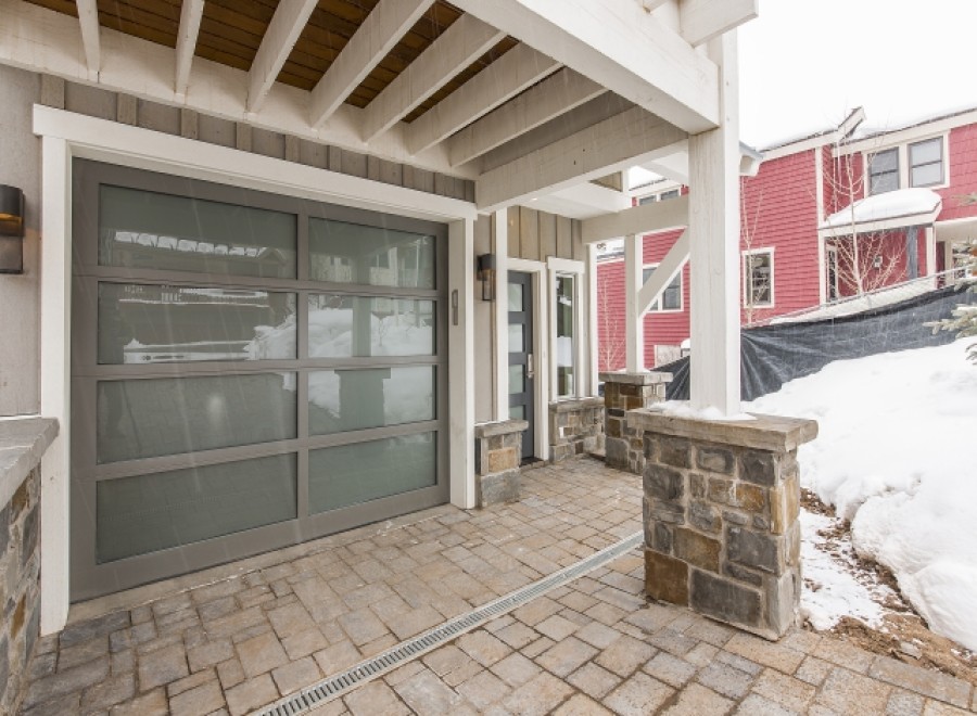 This stunning property boasts a modern gray garage door with frosted glass panels, adding both style and functionality.