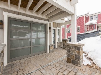 This stunning property boasts a modern gray garage door with frosted glass panels, adding both style and functionality.