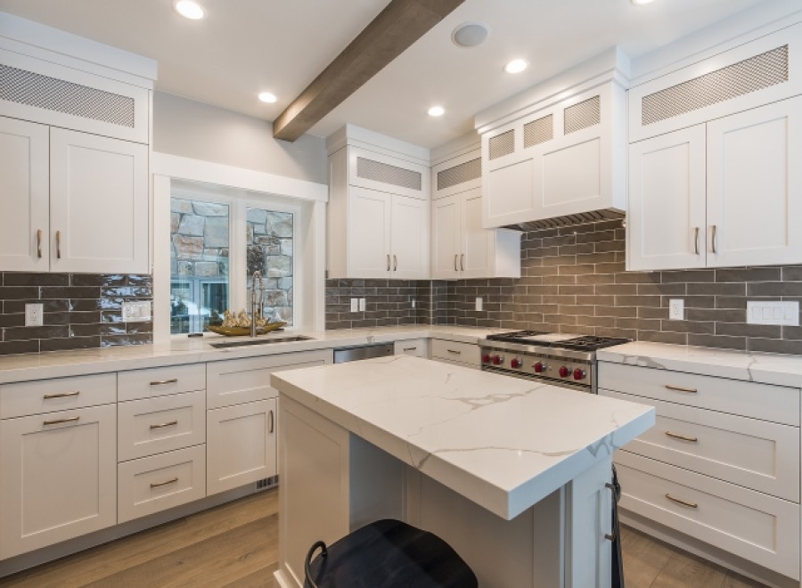 This stunning kitchen boasts a large island with white quartz countertops, perfect for casual dining or meal prep.