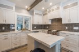 This stunning kitchen boasts a large island with white quartz countertops, perfect for casual dining or meal prep.