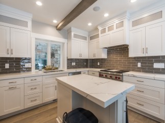 This stunning kitchen boasts a large island with white quartz countertops, perfect for casual dining or meal prep.