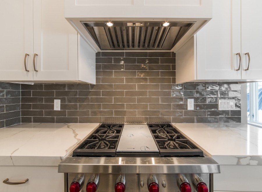 This stunning kitchen boasts a sleek, modern design with high-end stainless steel appliances and a beautiful marble countertop.