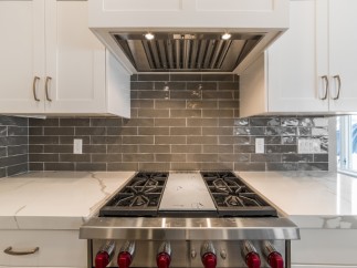 This stunning kitchen boasts a sleek, modern design with high-end stainless steel appliances and a beautiful marble countertop.