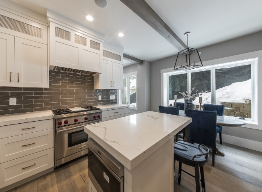 Stunning kitchen with white cabinets, marble countertops, and high-end stainless steel appliances.