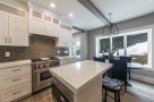 Stunning kitchen with white cabinets, marble countertops, and high-end stainless steel appliances.