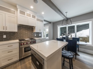 Stunning kitchen with white cabinets, marble countertops, and high-end stainless steel appliances.