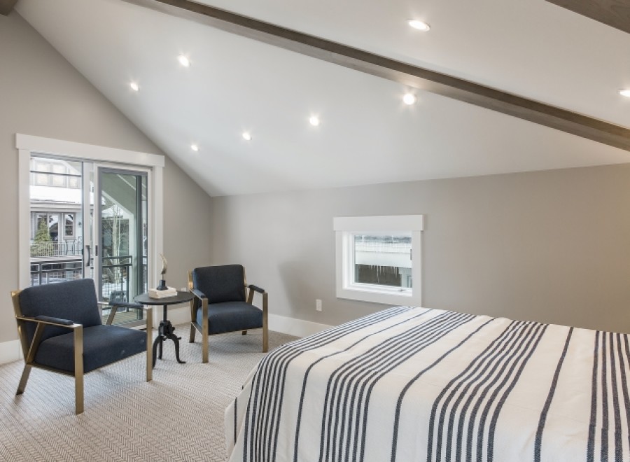This stunning bedroom boasts a vaulted ceiling with exposed beams, creating an airy and spacious feel.
