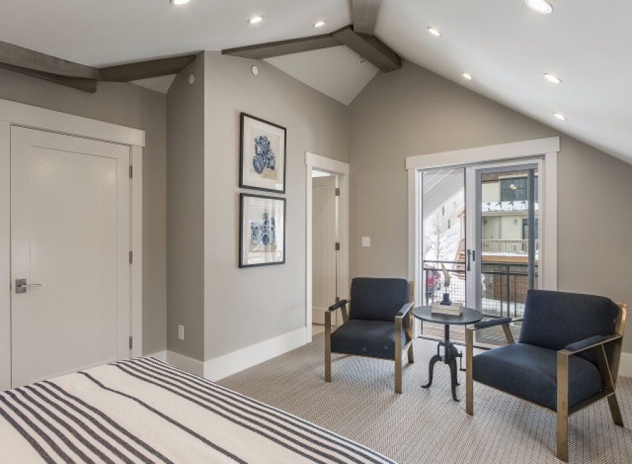 This stunning bedroom boasts a vaulted ceiling with exposed beams, creating an airy and spacious feel.