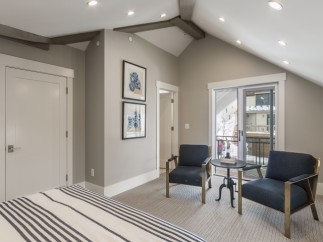 This stunning bedroom boasts a vaulted ceiling with exposed beams, creating an airy and spacious feel.