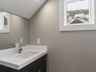 This stunning bathroom boasts a modern vanity with quartz countertops and sleek fixtures.