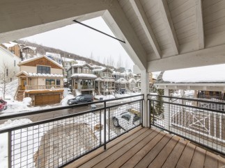 Enjoy breathtaking mountain views from this stunning balcony, complete with a modern metal railing and spacious wooden deck.