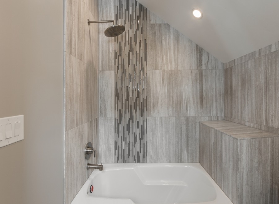 This luxurious bathroom boasts a spacious bathtub and shower combination, complete with modern fixtures and a stunning tile design.