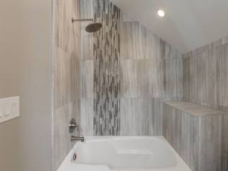 This luxurious bathroom boasts a spacious bathtub and shower combination, complete with modern fixtures and a stunning tile design.