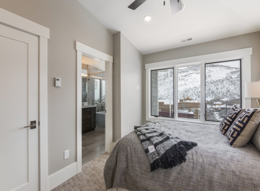 This stunning bedroom boasts a tranquil atmosphere with large windows offering breathtaking mountain views.