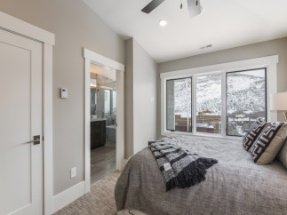 This stunning bedroom boasts a tranquil atmosphere with large windows offering breathtaking mountain views.
