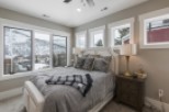 Mountain view bedroom with cozy bedding and large windows.