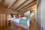 Experience the charm of this stunning bedroom, featuring a warm wooden ceiling and walls that create a cozy atmosphere.