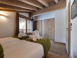 Discover the charm of this cozy bedroom, featuring exposed wooden beams and a warm, inviting atmosphere.