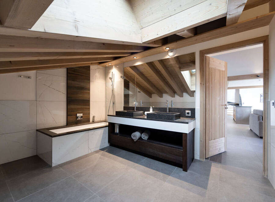 This luxurious bathroom boasts a modern design with a rustic touch, featuring exposed wooden beams and elegant marble tiling.