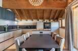 This stunning kitchen and dining area boasts a warm, inviting atmosphere with its exposed wooden beams and modern design.