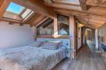 This stunning bedroom boasts a rustic charm with its exposed wooden beams and a cozy, inviting atmosphere.