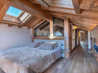 This stunning bedroom boasts a rustic charm with its exposed wooden beams and a cozy, inviting atmosphere.