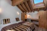 This cozy bedroom features two twin beds with luxurious faux fur throws and pillows, perfect for a comfortable stay.