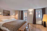 This cozy bedroom features a comfortable bed with a stylish throw blanket and pillows, perfect for a relaxing retreat.