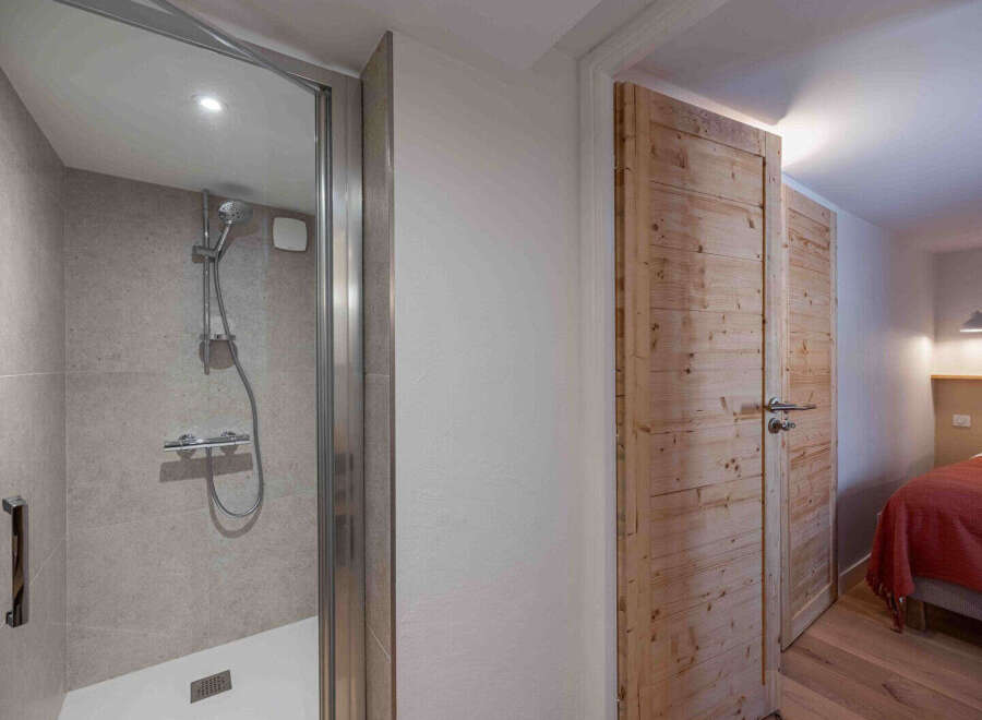 Step into this beautifully designed property featuring a modern shower and stylish wooden doors.