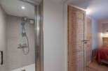 Step into this beautifully designed property featuring a modern shower and stylish wooden doors.