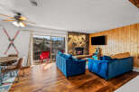 Step into this cozy living space, featuring a stunning stone fireplace and a modern flat-screen TV.