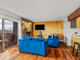 This stunning property boasts a cozy living area with a fireplace and a modern TV, perfect for relaxing evenings.
