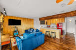 This stunning property boasts a cozy living area with a plush blue sofa, perfect for relaxing.