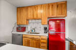 This charming kitchen features beautiful wooden cabinets, a stylish backsplash, and a modern stainless steel dishwasher.