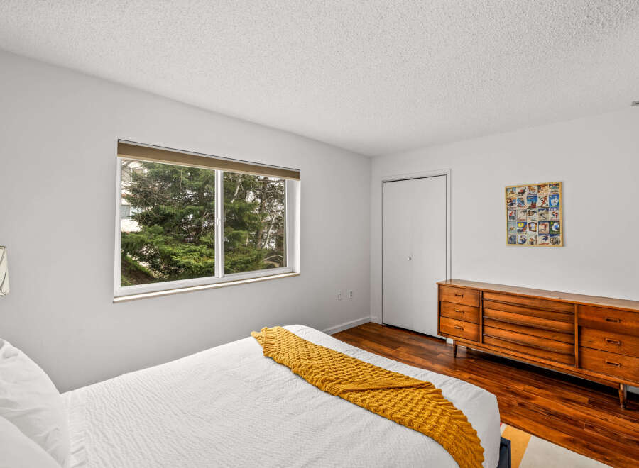 This inviting bedroom features a cozy atmosphere with a comfortable bed and a warm, textured throw.