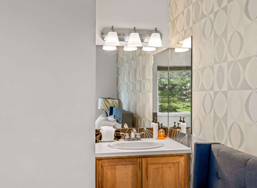 This bathroom features a stylish vanity with a sink and a mirror.