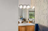 This bathroom features a stylish vanity with a sink and a mirror.