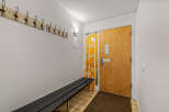 This entryway features a welcoming atmosphere with a wooden door and a stylish bench.