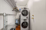 This laundry room features a modern stacked washer and dryer, maximizing space and efficiency.