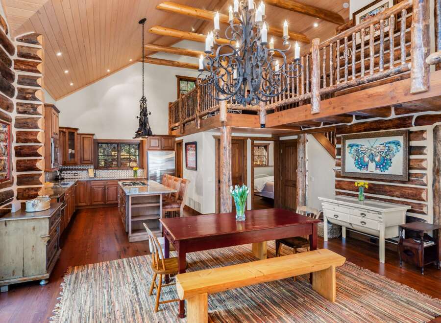 This stunning property boasts a rustic charm with its exposed log walls and wooden accents throughout.