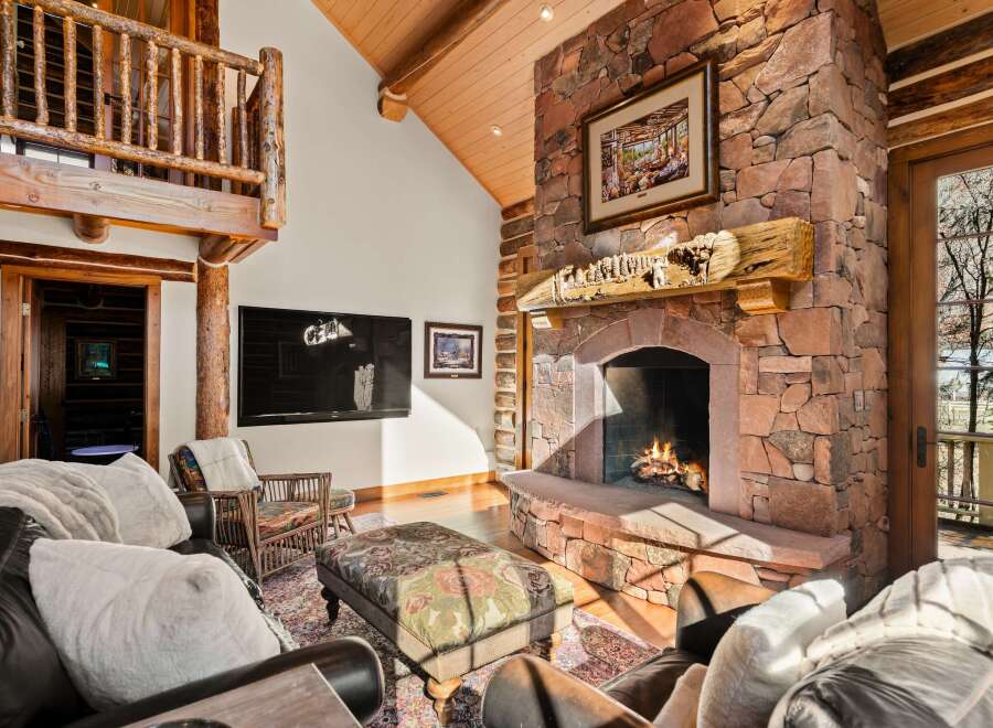 This stunning property boasts a cozy living room with a stone fireplace, perfect for chilly evenings.