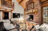 This stunning property boasts a cozy living room with a stone fireplace, perfect for chilly evenings.