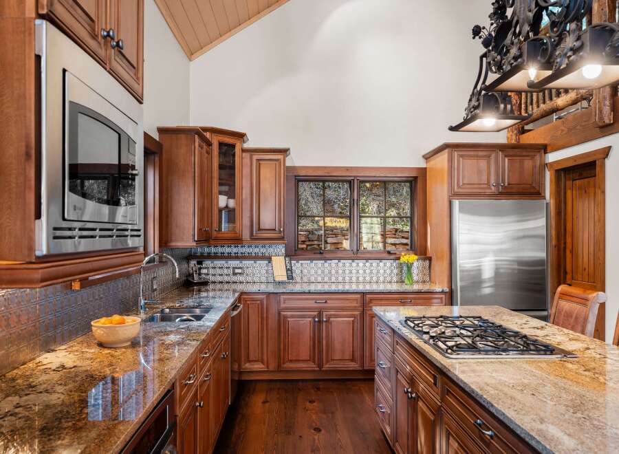 This stunning kitchen boasts custom cabinetry, granite countertops, and stainless steel appliances.